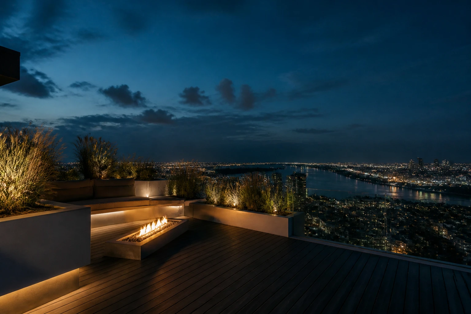 Terraza en el último piso a la hora azul, con deck de madera y vista a la ciudad.