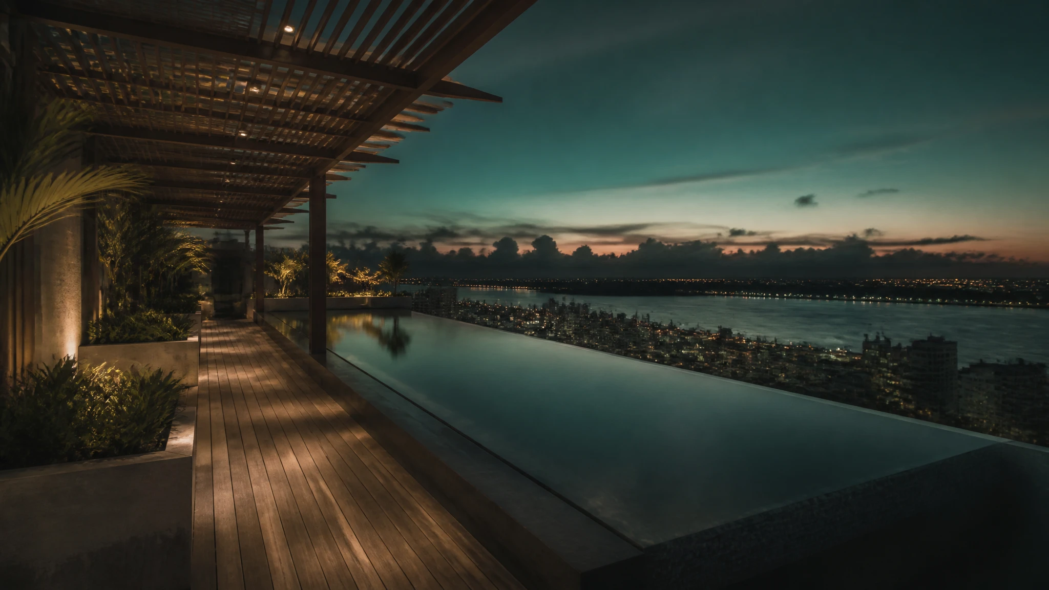 Piscina de borde infinito en la terraza de Miramar Elite al anochecer, con la ciudad al fondo.